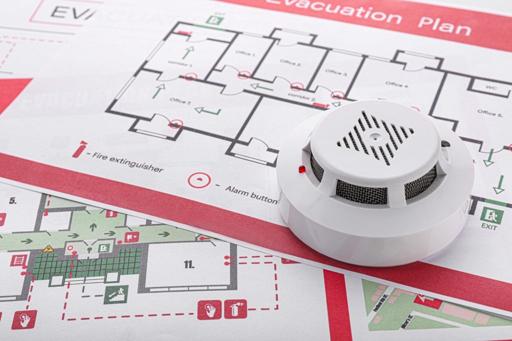 Smoke detector placed on building fire evacuation and emergency safety plans